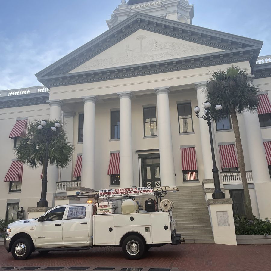 A Chaney's service truck staged at the columned portico of Tallahassee's Historic Capitol building, striped awnings and palm trees framing the entrance.